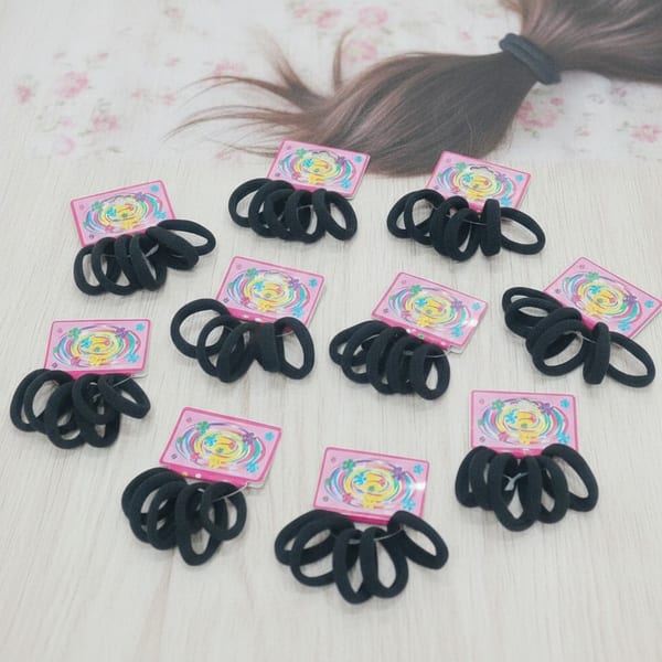 Lote de 12 tarjetas con colitas elásticas negras para el pelo sobre fondo claro