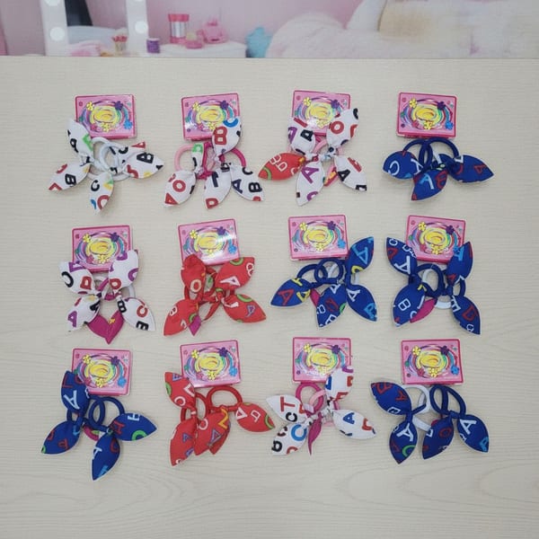 Tarjetas con colitas para el pelo decoradas con lazos de tela y estampado de letras