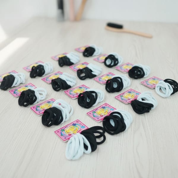 Tarjetas exhibidoras con colitas elásticas para el pelo en colores blanco y negro