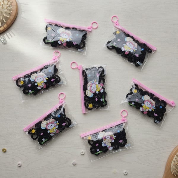 Paquetes transparentes con cierre rosa conteniendo colitas para el pelo negras con figuras decorativas