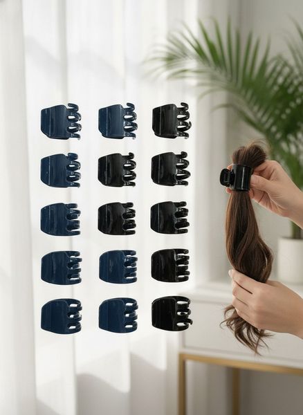 Doce broches plásticos para el pelo en colores azul y negro organizados en filas sobre una superficie.