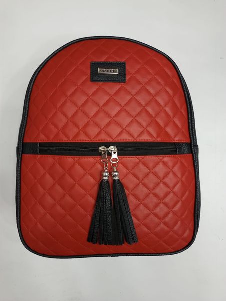 Mochila urbana de mujer en ecocuero matelassé rojo con detalles y borlas en negro.