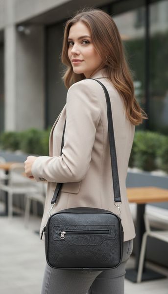 Bandolera de ecocuero negro texturizado con bolsillo frontal con cierre y correa regulable