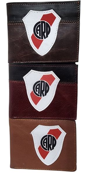 Tres billeteras de símil cuero en tonos marrón, borravino y suela con el escudo de River Plate