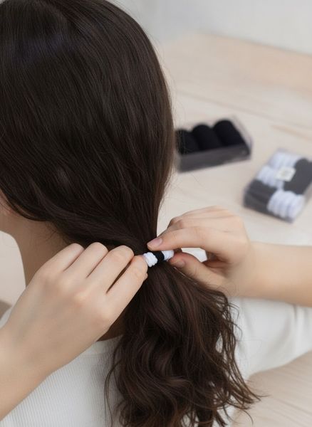 Cajas plásticas transparentes con colitas de pelo elásticas en color negro y blanco