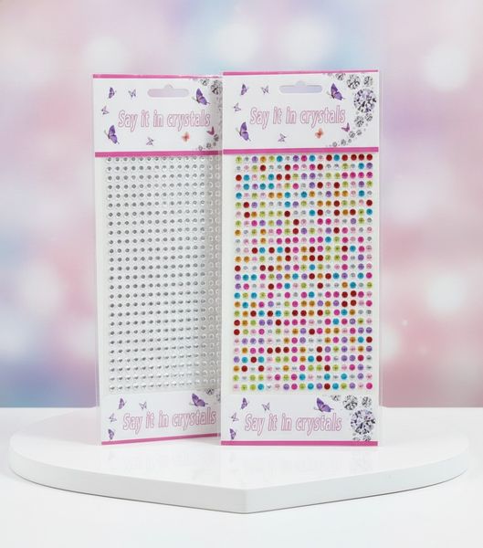 Dos planchetas de gemas strass autoadhesivas transparentes y de colores en su empaque