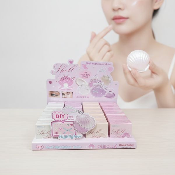 Exhibidor con cajas de iluminador en bálsamo marca OliBolla Shell Bling en forma de caracola