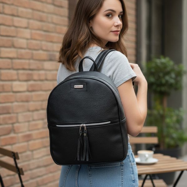 Mochila urbana de ecocuero negro con bolsillo frontal y tiradores con flecos