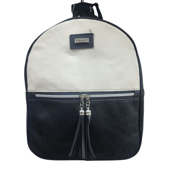 Mochila urbana de ecocuero bicolor en tonos blanco crema y negro con bolsillo frontal y tiradores de flecos.