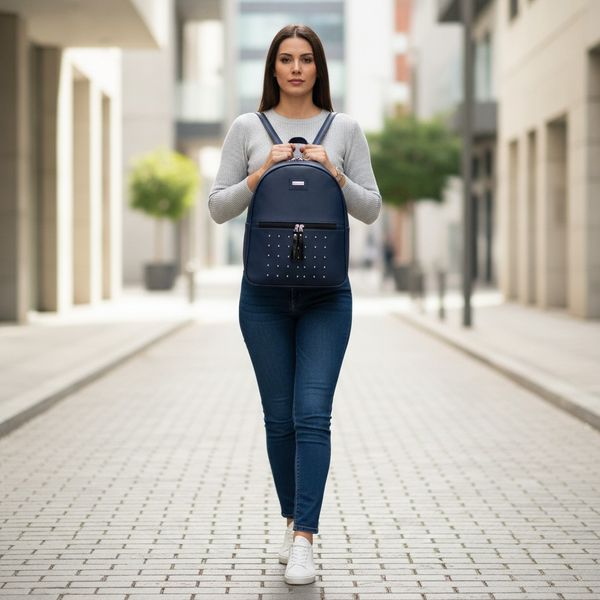 Mochila urbana de ecocuero con tachas y bolsillo frontal en colores azul marino y marrón
