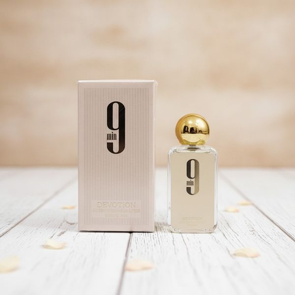 Frasco de perfume 9 Min Devotion con tapa dorada junto a su caja de presentación