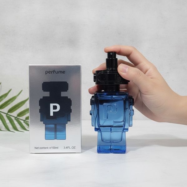 Frasco de perfume transparente de color azul con forma de robot junto a su caja plateada