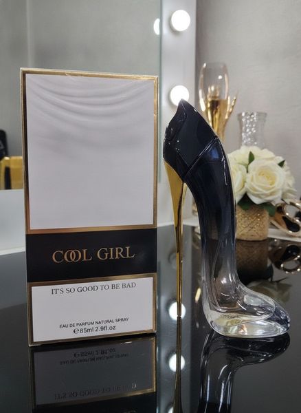 Perfume de mujer con frasco en forma de zapato de taco azul y dorado junto a su caja Cool Girl