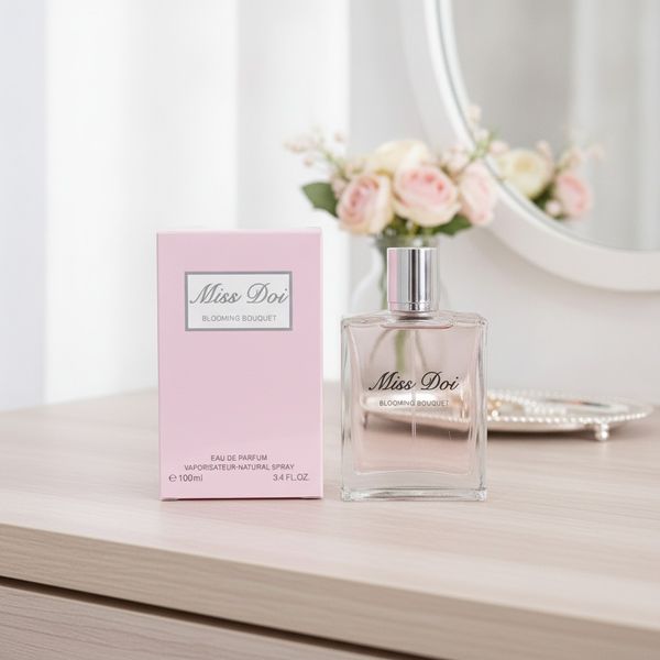 Perfume Miss Doi Blooming Bouquet de 100 ml en frasco de vidrio transparente junto a su caja rosa
