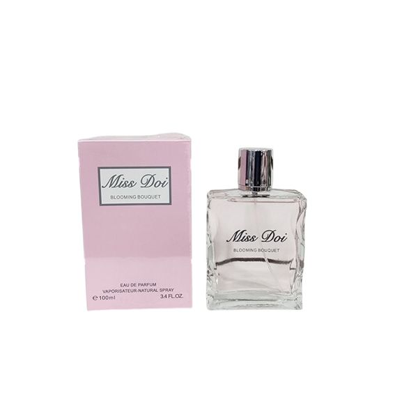 Perfume Miss Doi Blooming Bouquet de 100 ml en frasco de vidrio transparente junto a su caja rosa