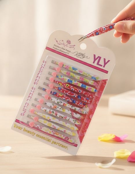 Blíster con 12 pinzas metálicas para depilar con estampados florales y detalles de corazón