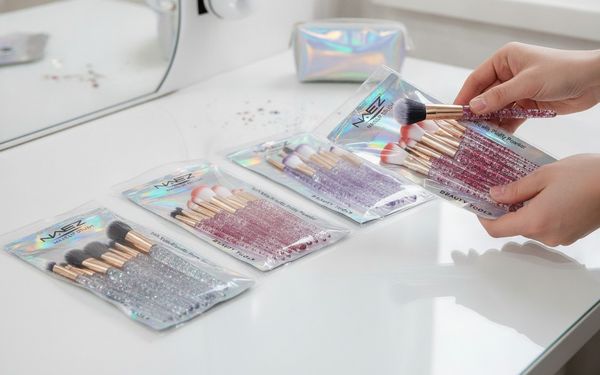 Sets de brochas de maquillaje con mangos transparentes con glitter en varios colores.