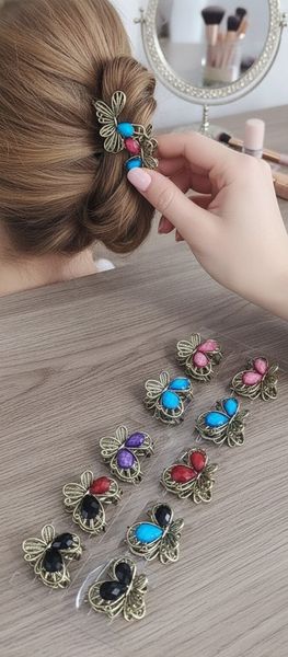 Tira exhibidora con broches metálicos para el pelo con forma de mariposa y piedras de colores