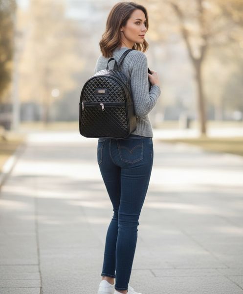 Mochila urbana de mujer negra con textura matelassé brillante y bolsillo frontal