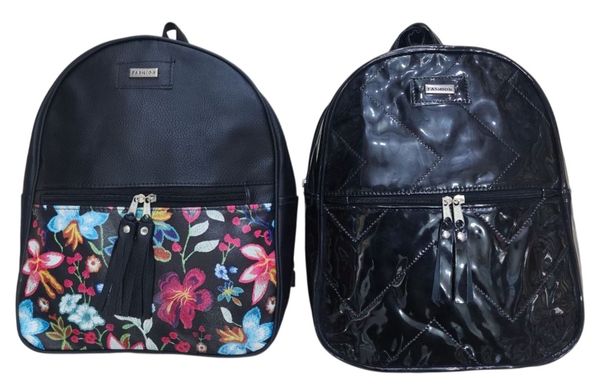 Dos mochilas negras de mujer, una con bolsillo estampado floral y otra con acabado en charol matelasseado.