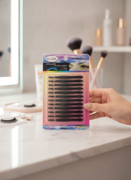 Blíster con 12 pinzas aplicadoras de plástico negro para pestañas postizas marca Ai Li Sha.