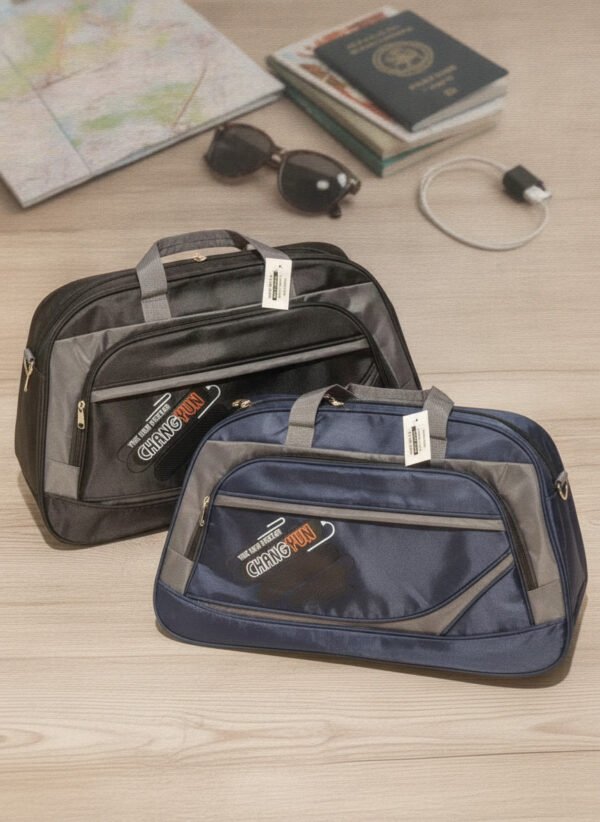 Bolso-de-Viaje-con-Bolsillo-Frontal-Colores-Surtidos-2-unidades-comercial-1.jpg Dos bolsos de viaje confeccionados en tela, uno negro con gris y otro azul marino con gris.